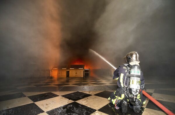 Пожарный тушит огонь в Соборе Парижской богоматери