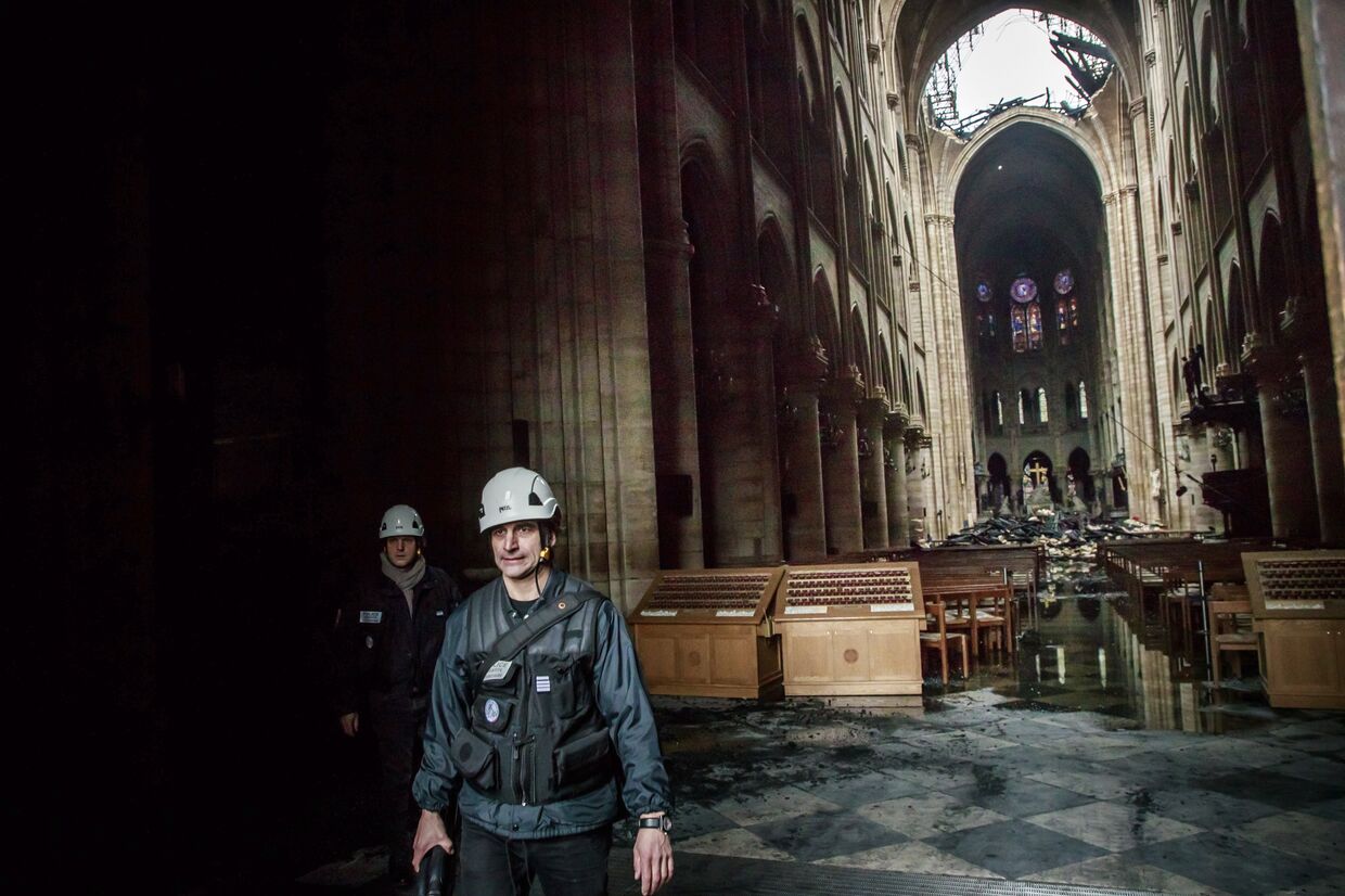 Человек в Соборе Парижской богоматери после 12-часового тушения пожара