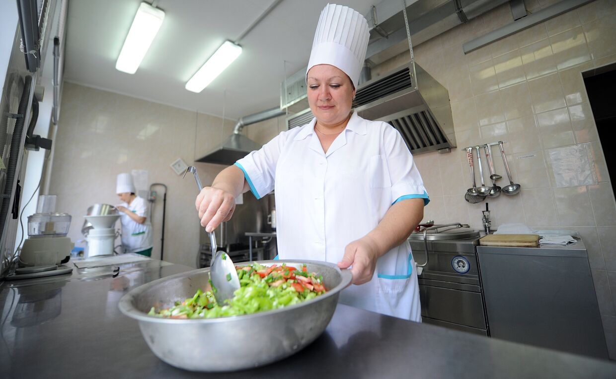 Работница пищеблока детского сада №406 готовит овощной салат