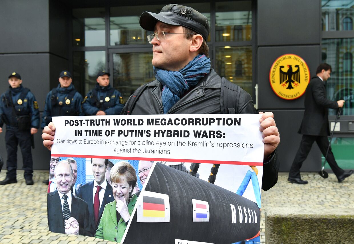Мужчина с плакатом, протестующий против российско-немецкого газопровода «Северный поток»