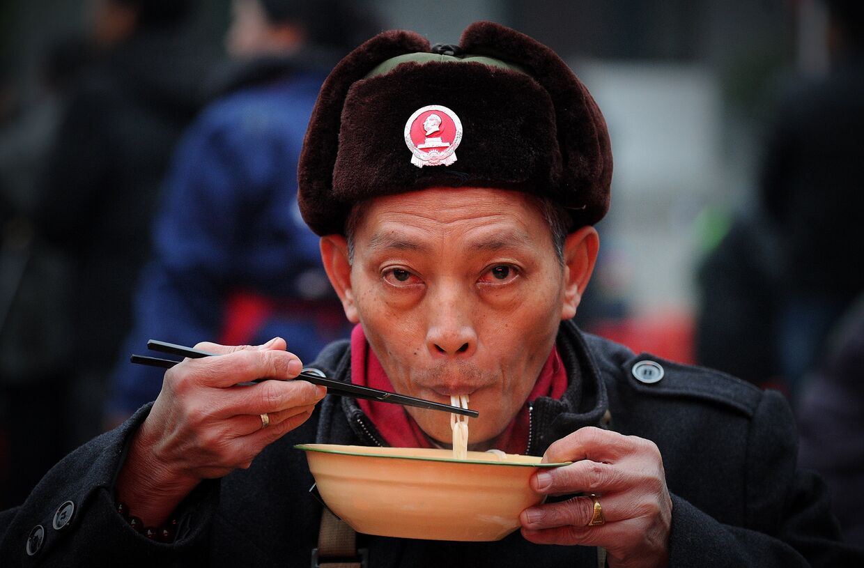 Человек ест лапшу в Шаошане, Китай