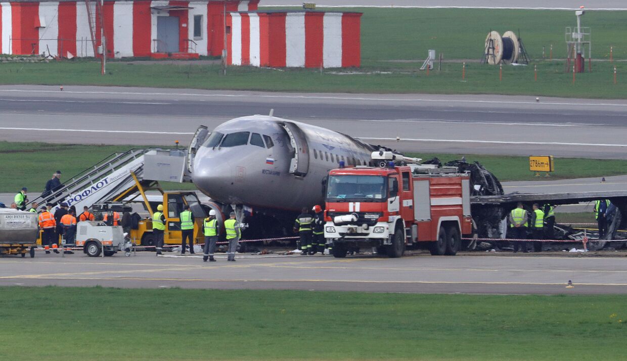 Сотрудники экстренных служб на месте аварии пассажирского самолета Sukhoi Superjet-100 в аэропорту Шереметьево