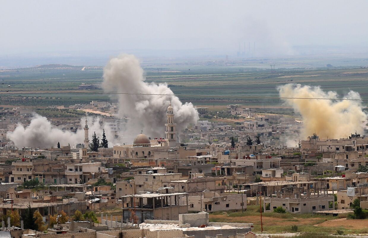 Дым во время обстрела города Хан-Шейхун в провинции Идлиб, Сирия