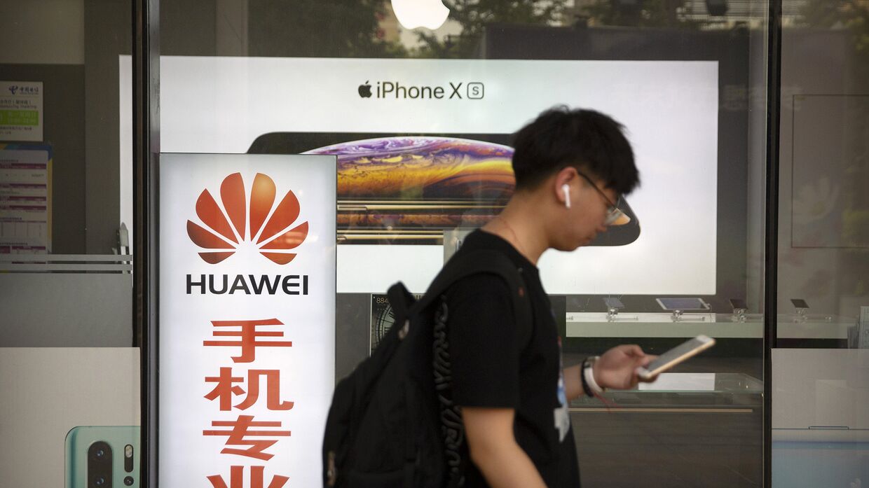 Прохожий на фоне витрины магазина электроники в Пекине