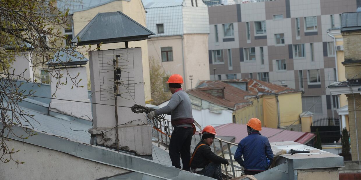 Рабочие-строители на крыше здания в Москве