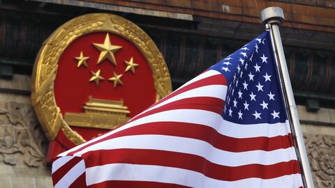 Флаг США на фоне эмблемы Китая в Пекине