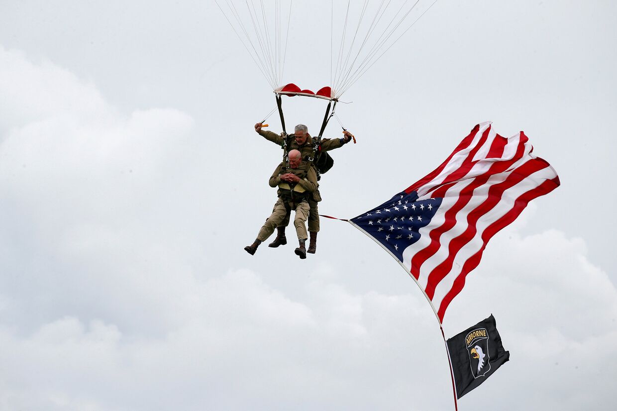 Ветеран-десантник Второй мировой войны США Том Райс прыгает во время памятного прыжка с парашютом над Карантаном на побережье Нормандии в преддверии 75-й годовщины D-Day