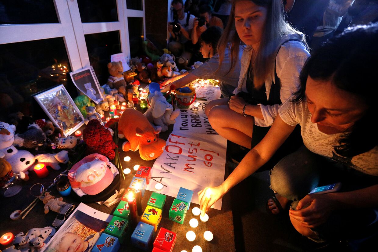 Портрет погибшего мальчика и свечи у здания департамента полиции в Киеве