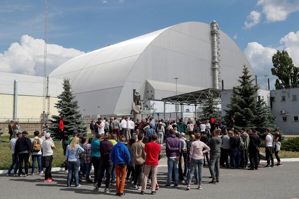 Туристы у нового безопасного саркофага над разрушенным в результате аварии 4-м энергоблоком Чернобыльской АЭС