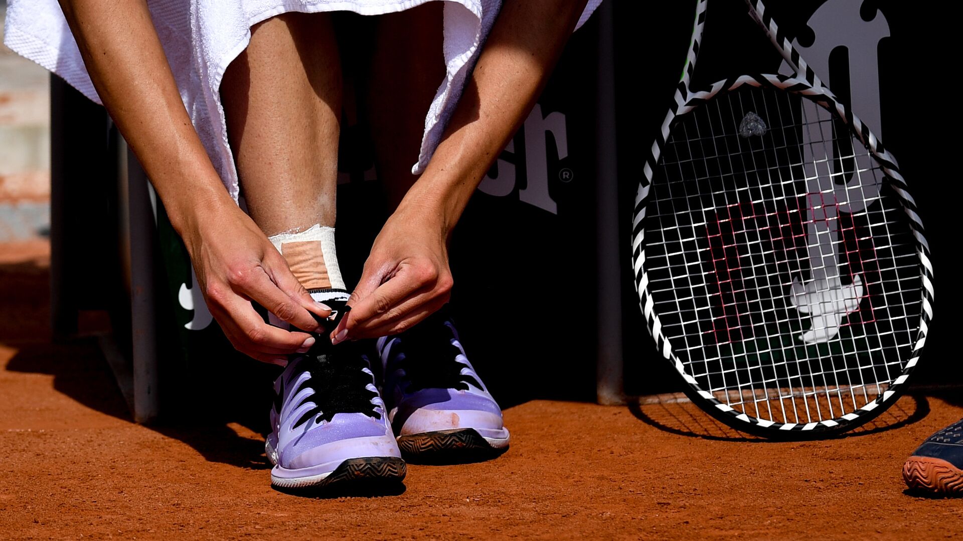 Теннисистка завязывает шнурки на кроссовках перед матчем - ИноСМИ, 1920, 07.06.2023