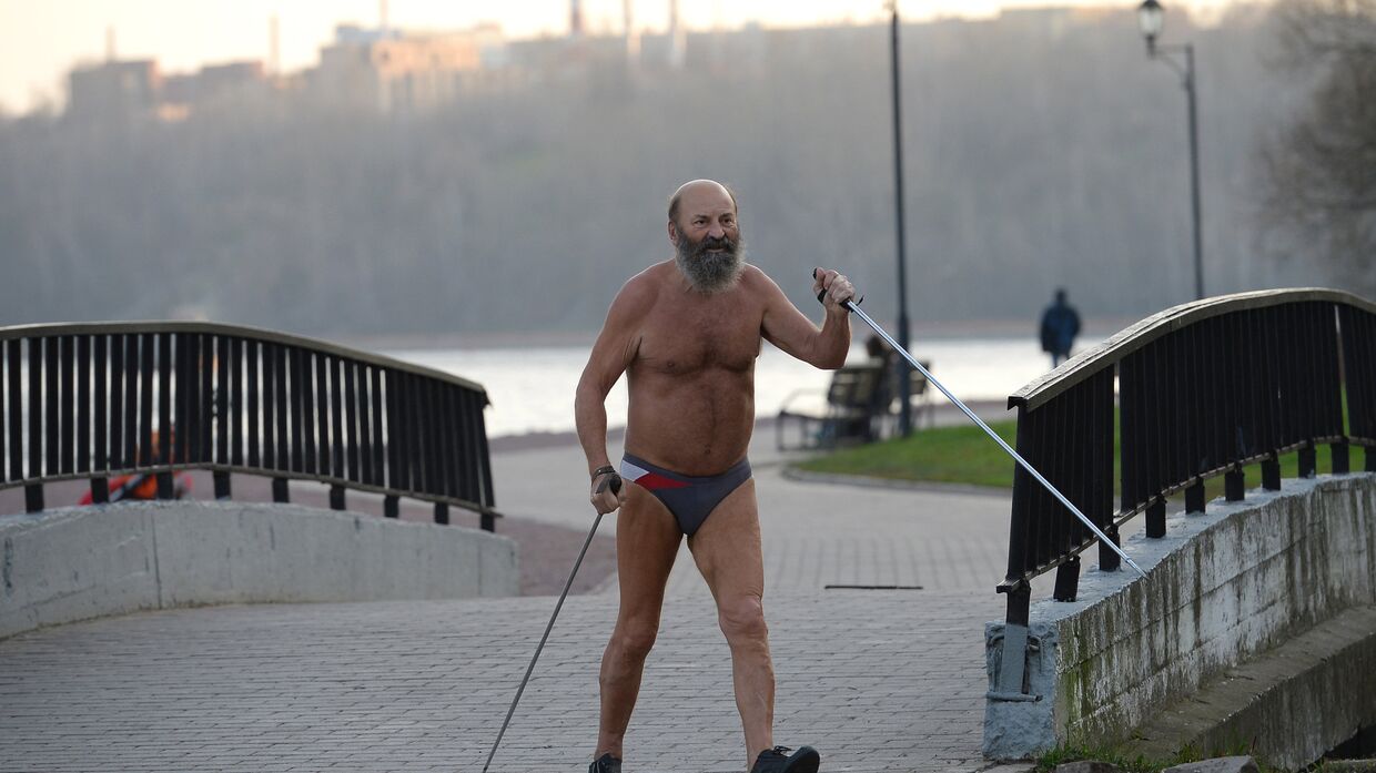 Мужчина занимается скандинавской ходьбой в жару