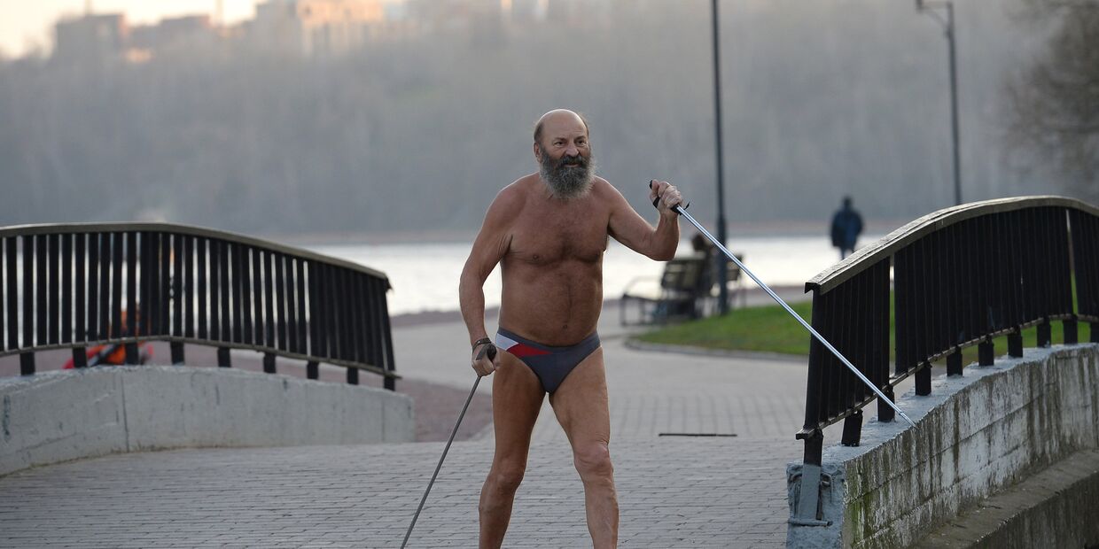 Мужчина занимается скандинавской ходьбой в жару
