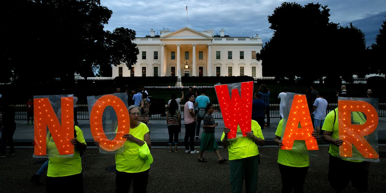 Протестующие с надписью нет войне у Белого дома в Вашингтоне