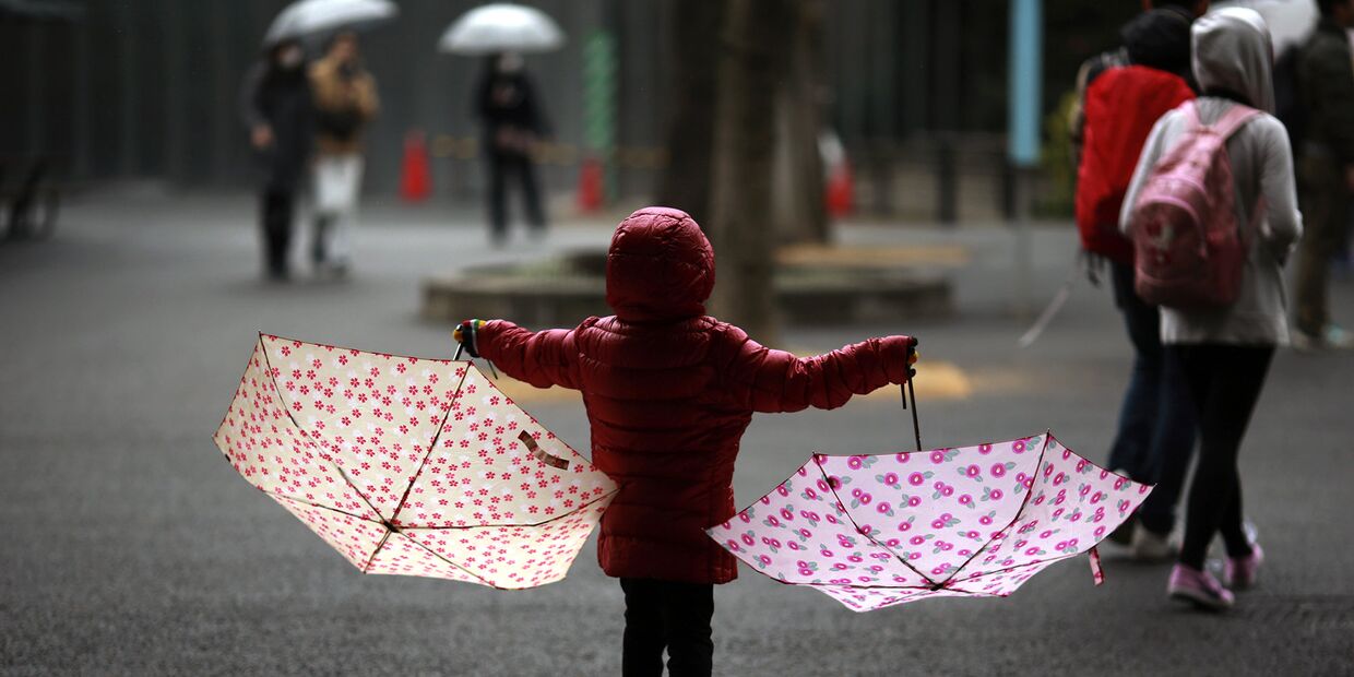 Девочка под дождем в парке в Токио
