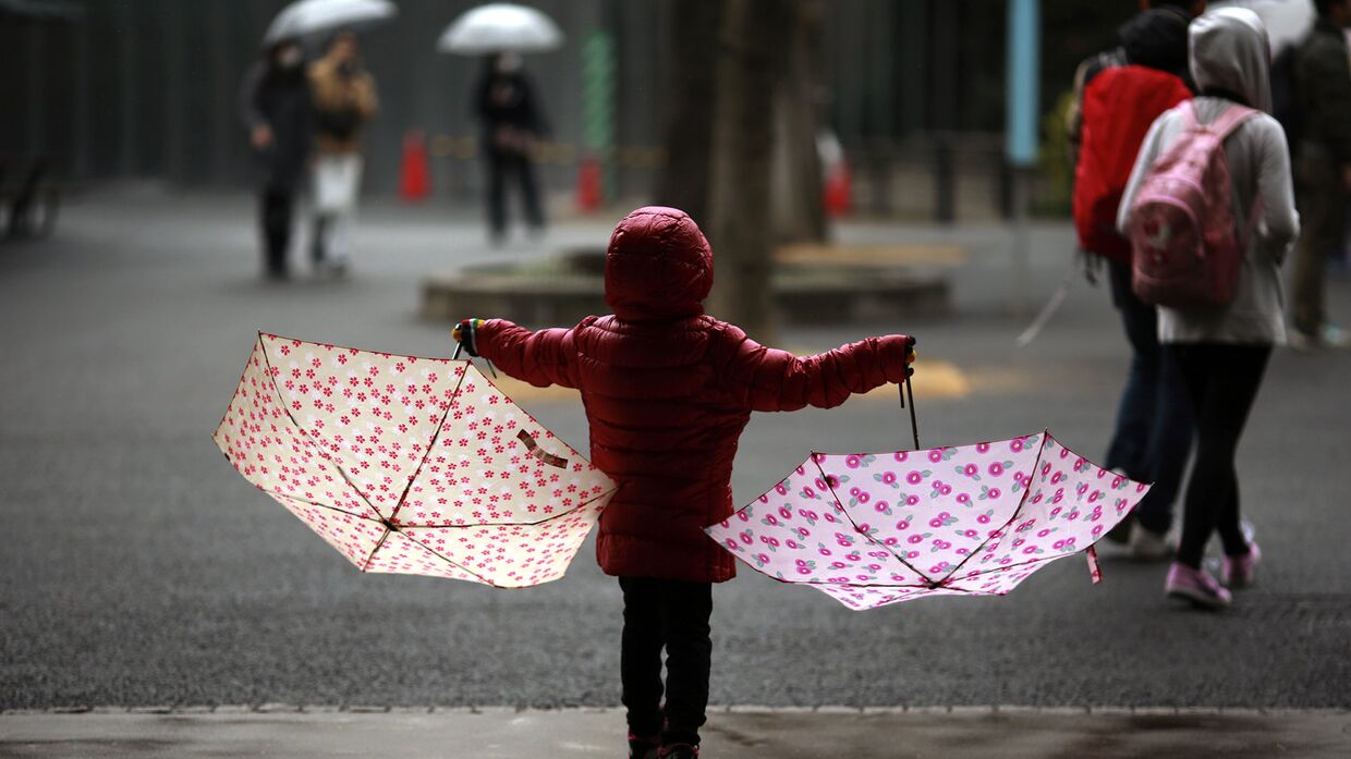 Девочка под дождем в парке в Токио
