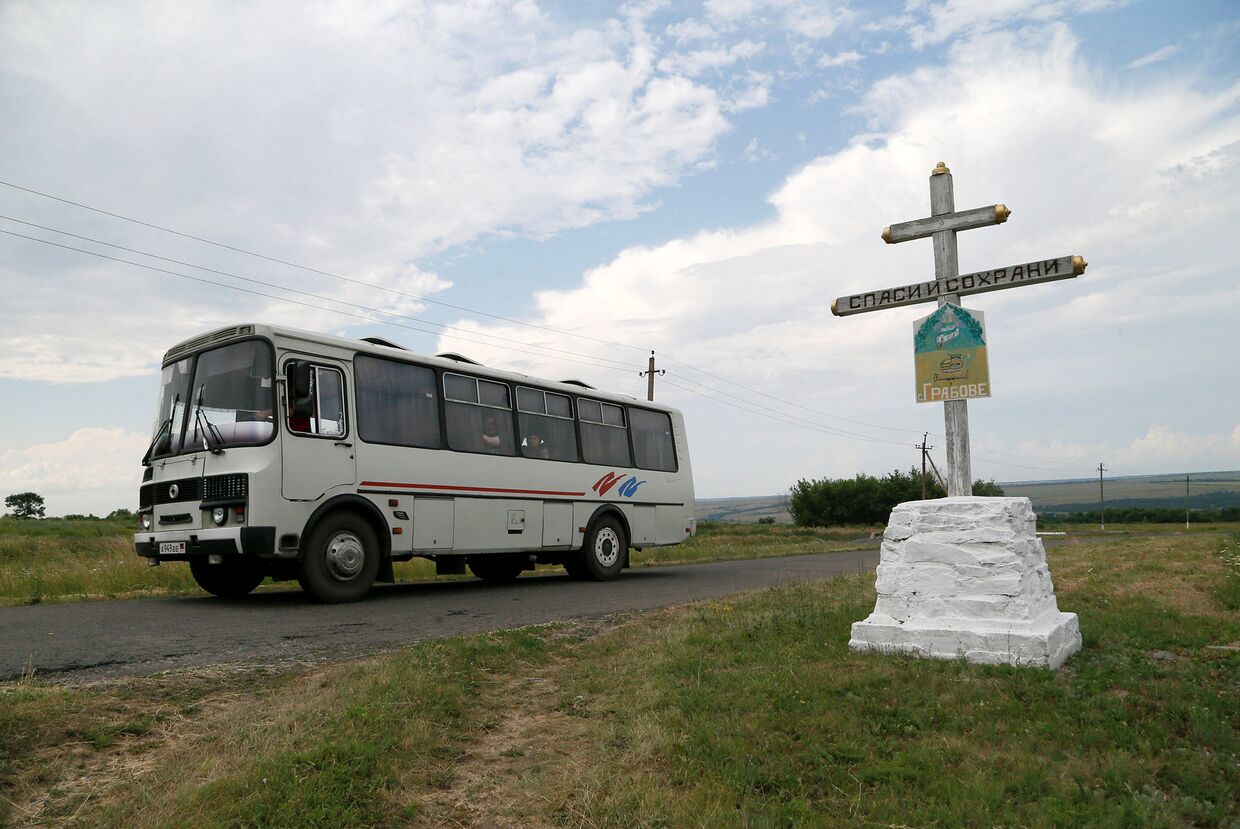 Автобус проезжает мимо места крушения самолета рейса MH17 авиакомпании Malaysia Airlines в районе села Грабово Донецкой области