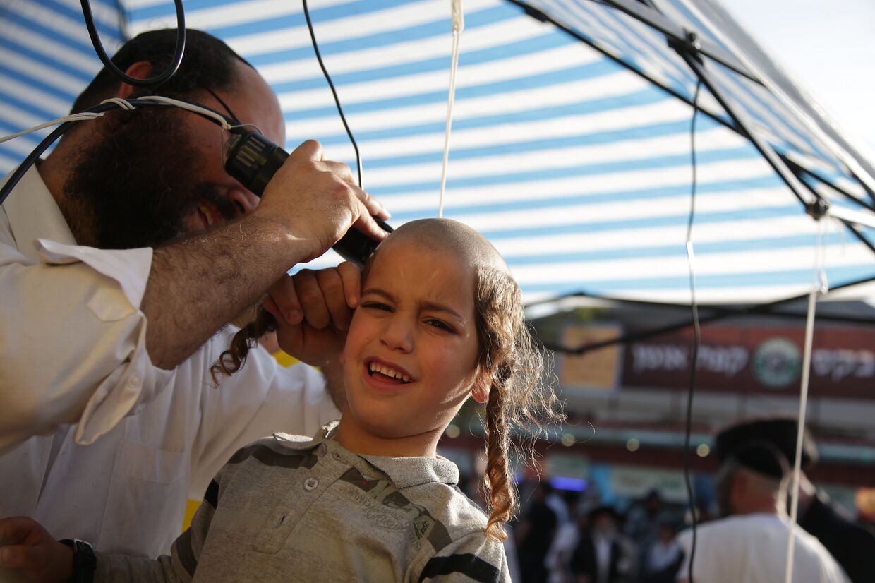 Еврей-хасид стрижет ребенка в честь наступающего Нового года Рош ха-Шана