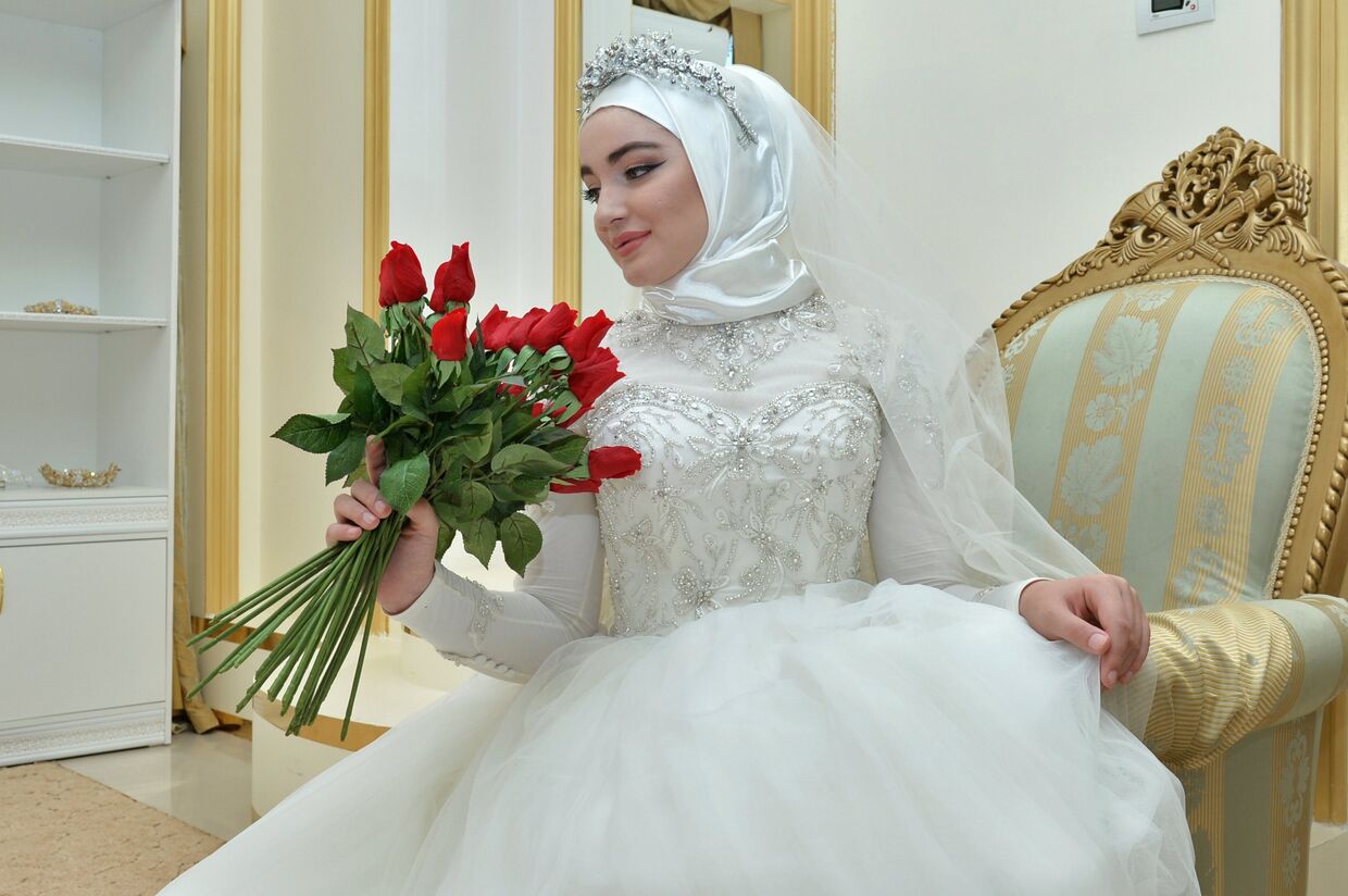 Модель демонстрирует свадебное платье в салоне магазина в Грозном