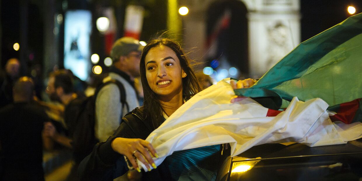 Девушка с флагом Алжира у Триумфальной арки в Париже
