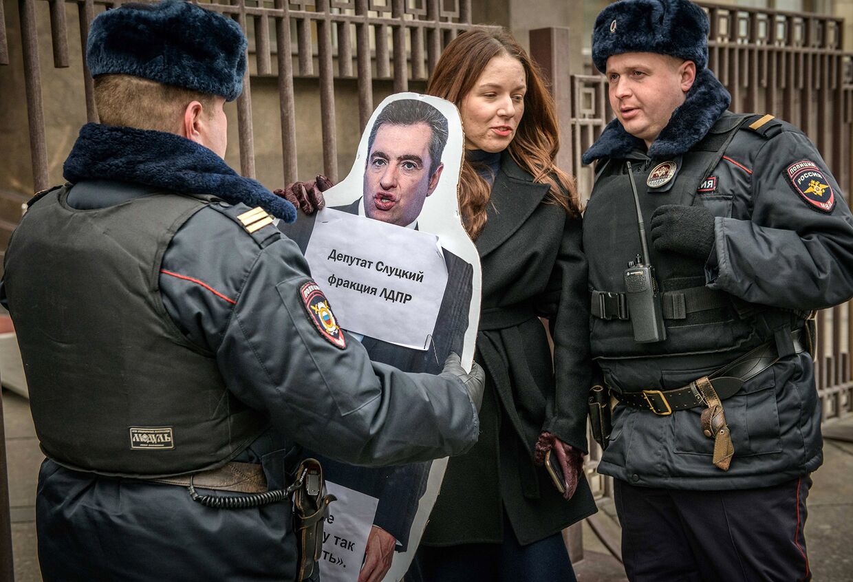 Сотрудники полиции задерживают активистку во время акции перед зданием Госдумы в Москве