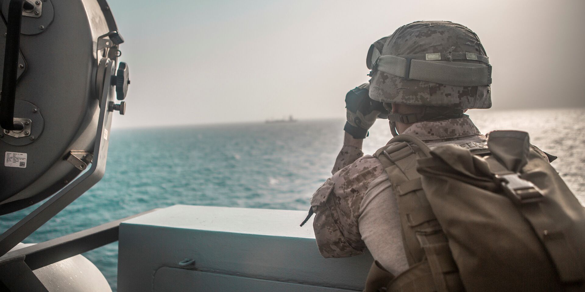 Американский военный смотрит в бинокль на корабль в Ормузском проливе - ИноСМИ, 1920, 14.04.2026