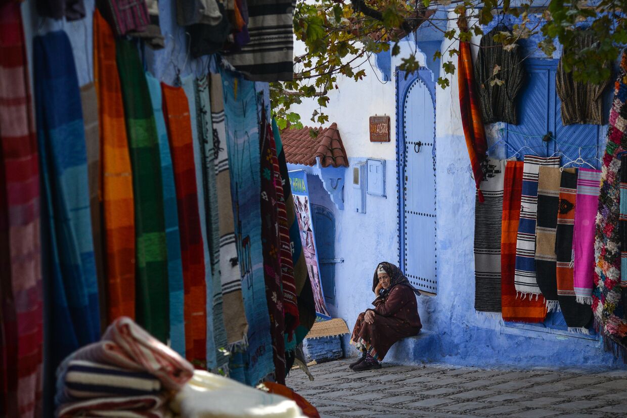 Женщина сидит на ступенях своего дома на одной из улиц города Шефшауэн