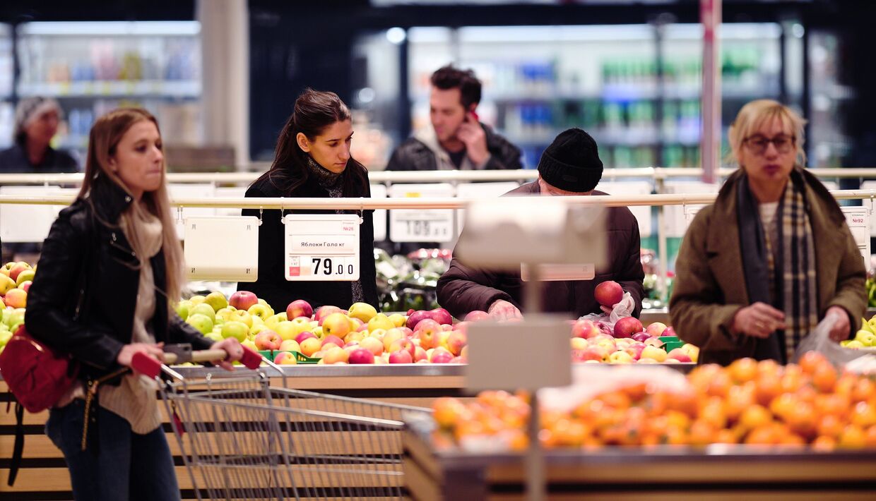 Покупатели у полок с фруктами в гипермаркете АШАН в торговом центре Капитолий в Москве