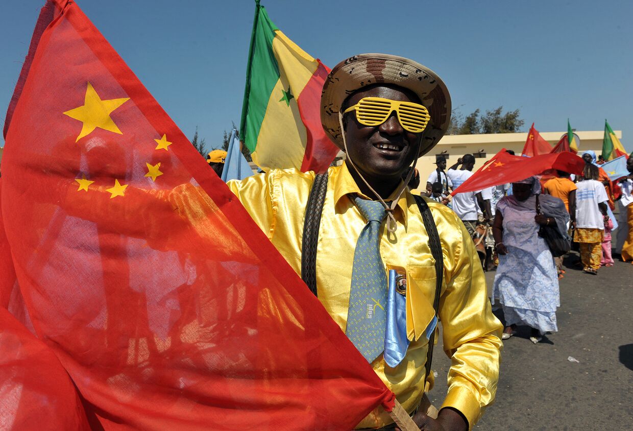 Сенегалец машет китайским флагом в Дакаре