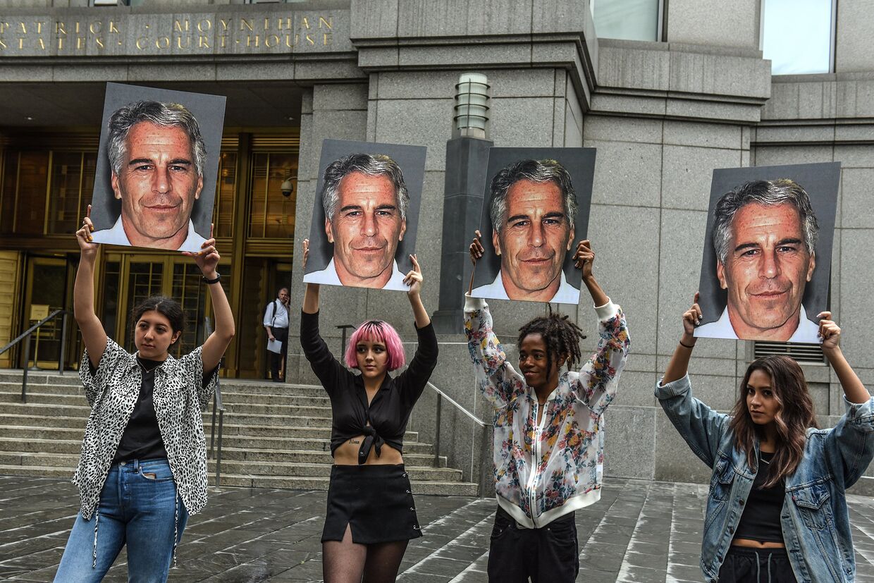Участницы акции протеста с фотографиями Джеффри Эпштейна