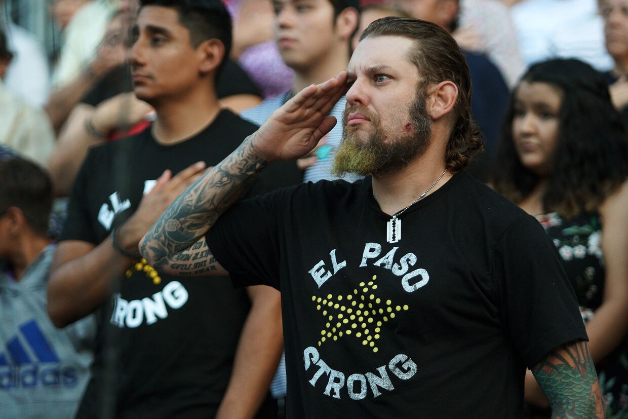 Мужчина отдает честь во время поминальной службы по жертвам августовской трагедии в Эль-Пасо