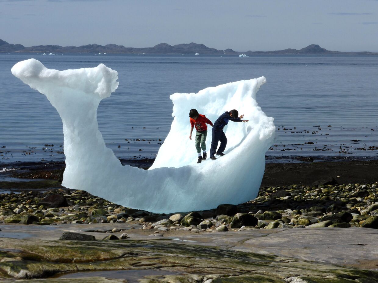 Дети играют с айсбергом в Нууке, Гренландия