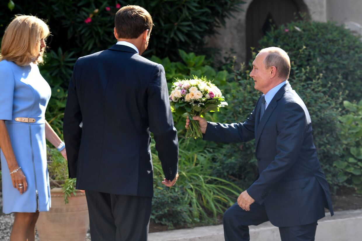 Путин дарит цветы жене президента Франции