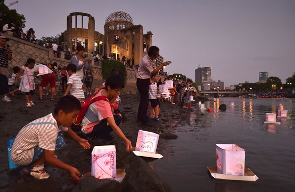 Люди пускают бумажные фонарики в реку Мотоясу в Хиросиме