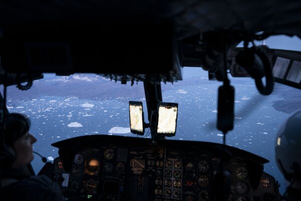 16 августа 2019. Вертолет пролетает над айсбергами вблизи ледника Хельхейм, Гренландия
