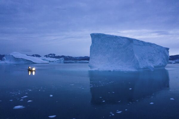Лодка лавирует среди айсбергов, Гренландия