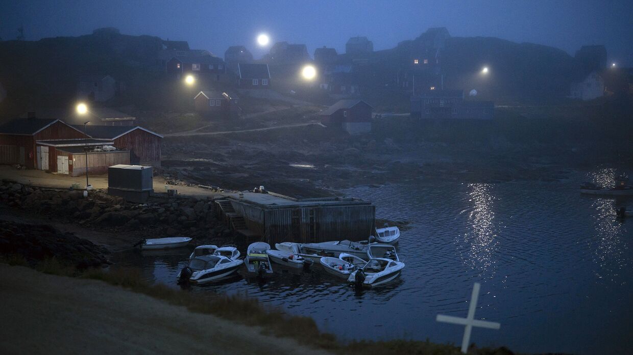 Крест на перекрестке дороги и дома в тумане,  Кулусук, Гренландия