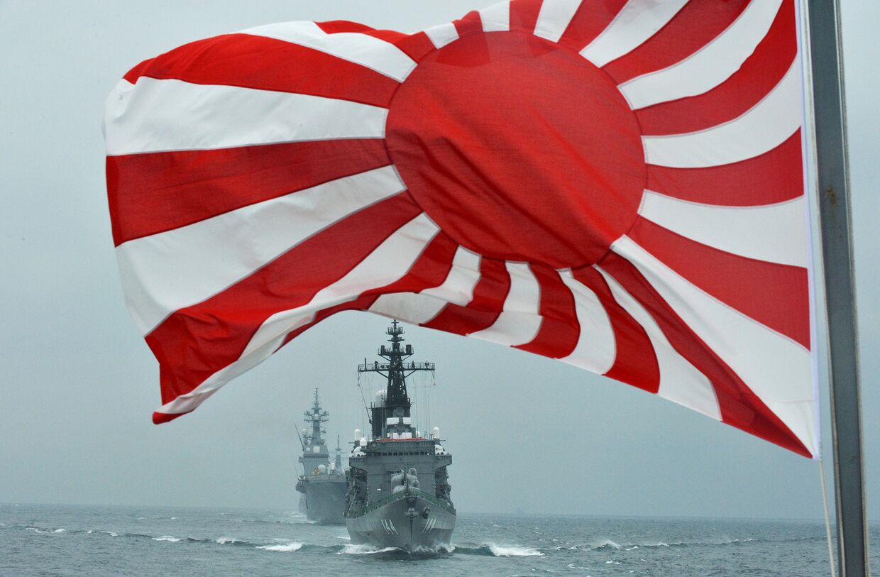 Флаг японских морских сил самообороны на фоне кораблей Kurama и Hyuga у залива Сагами