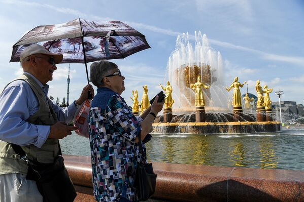 Пожилая пара у знаменитого фонтана Дружбы Народов на ВДНХ в Москве