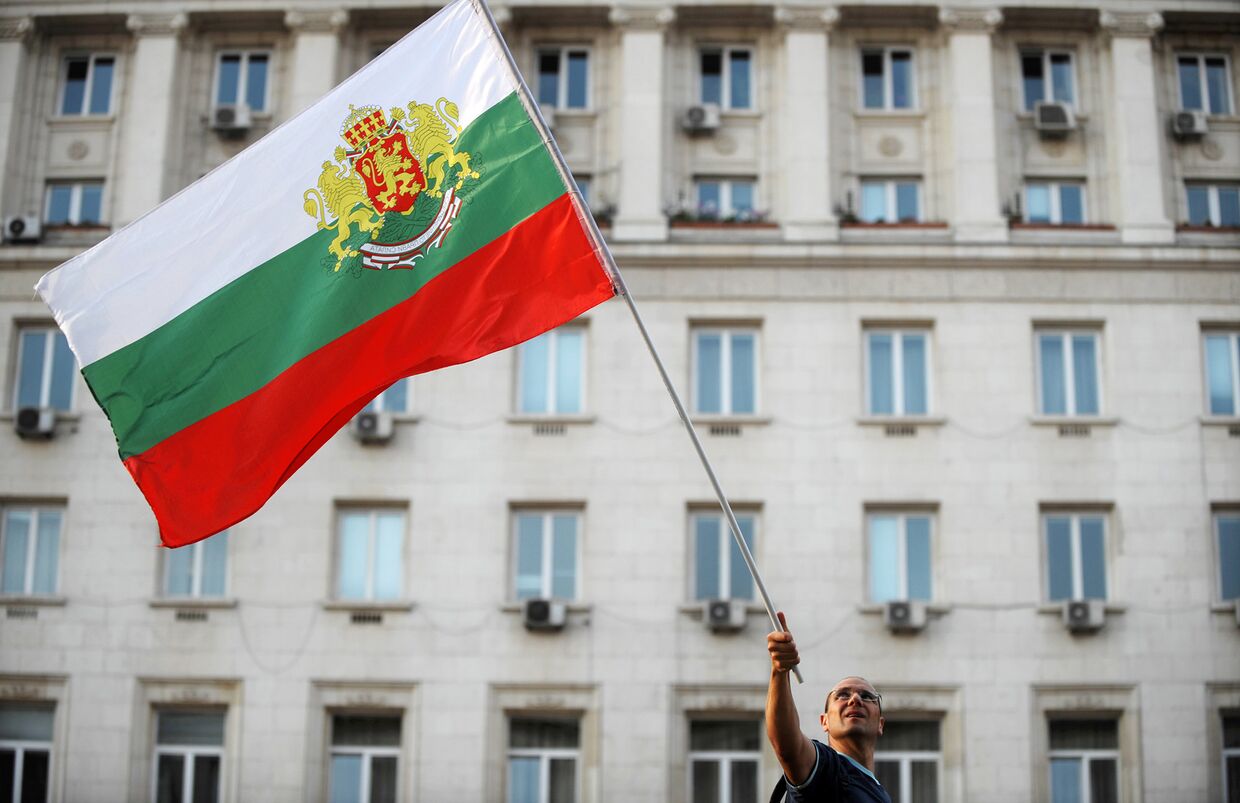Флаг в руках у участника акции протеста в Софии, Болгария