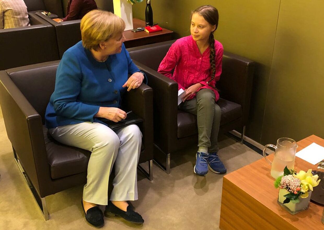 Канцлер Германии Ангела Меркель беседует с 16-летней шведской активисткой по климату Гретой Тунберг во время саммита ООН по климату