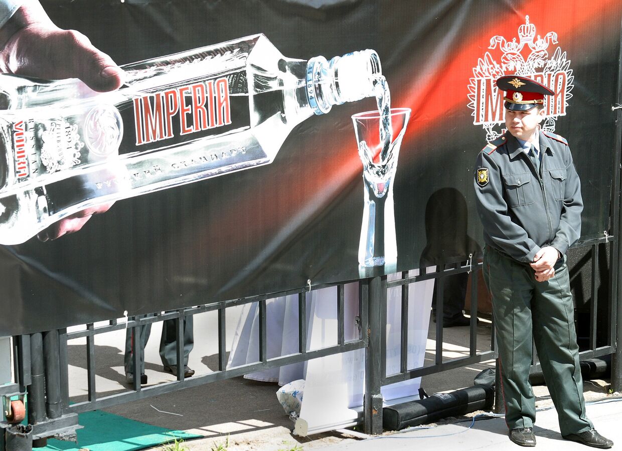 Сотрудник полиции на фоне рекламного щита с алкогольной продукцией