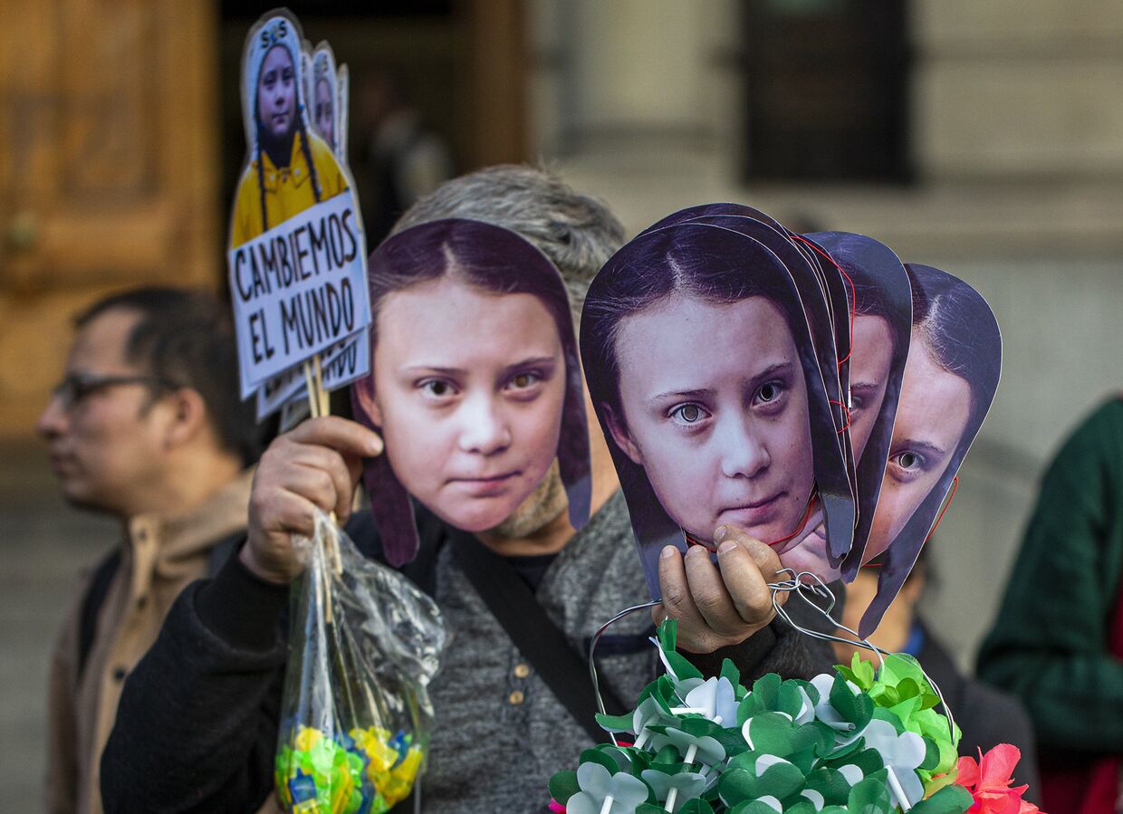Маски Греты Тунберг во время акции протеста против изменения климата в Сантьяго, Чили