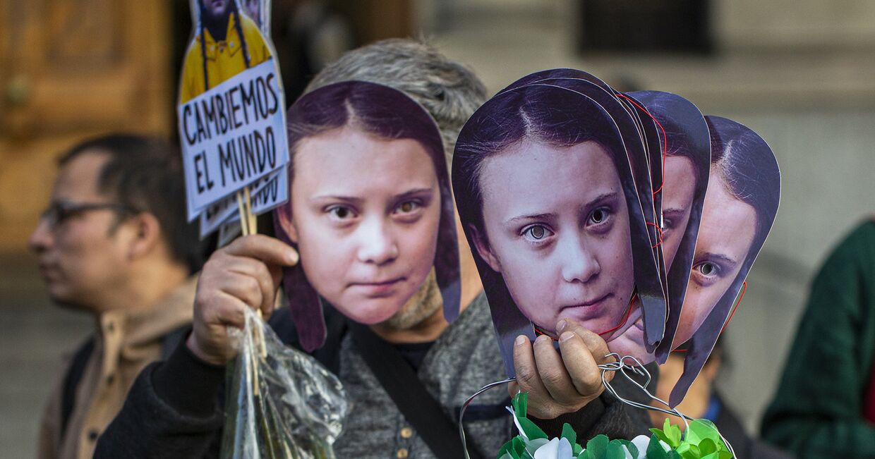 Маски Греты Тунберг во время акции протеста против изменения климата в Сантьяго, Чили