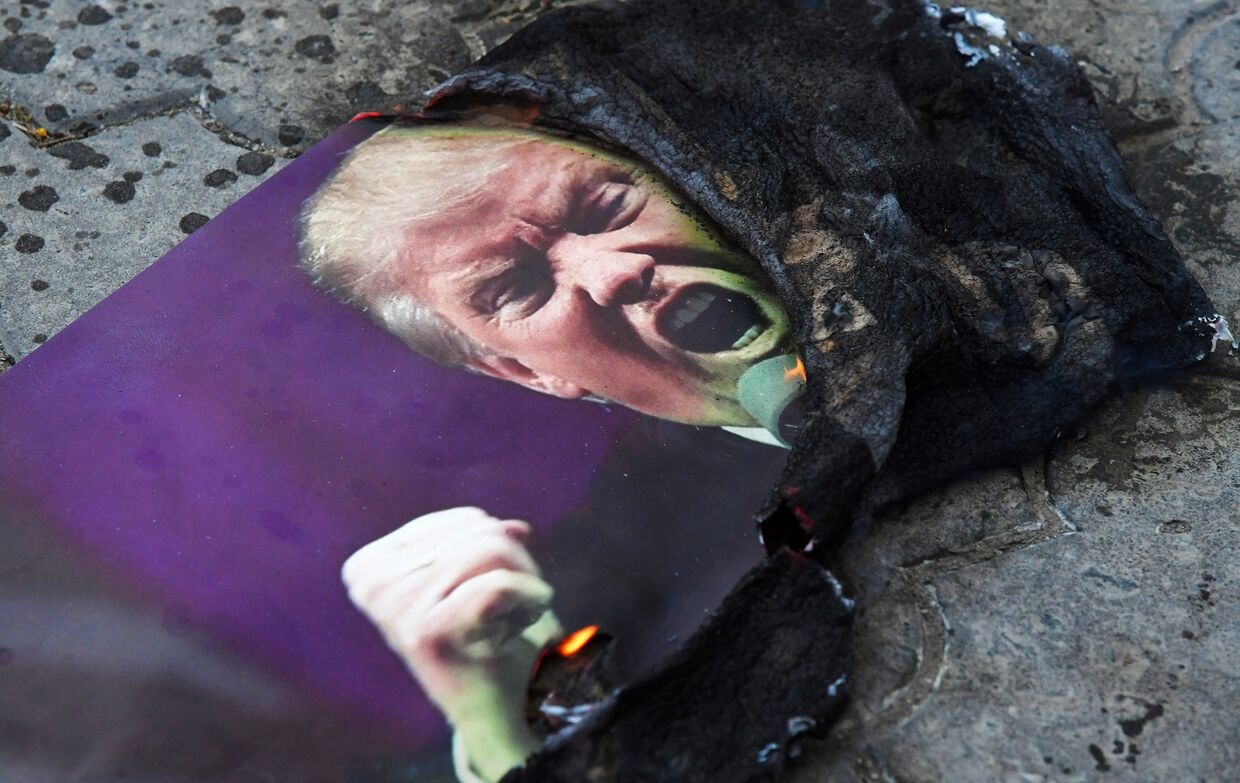 Портрет президента США Дональда Трампа, который подожгли участники акции протеста