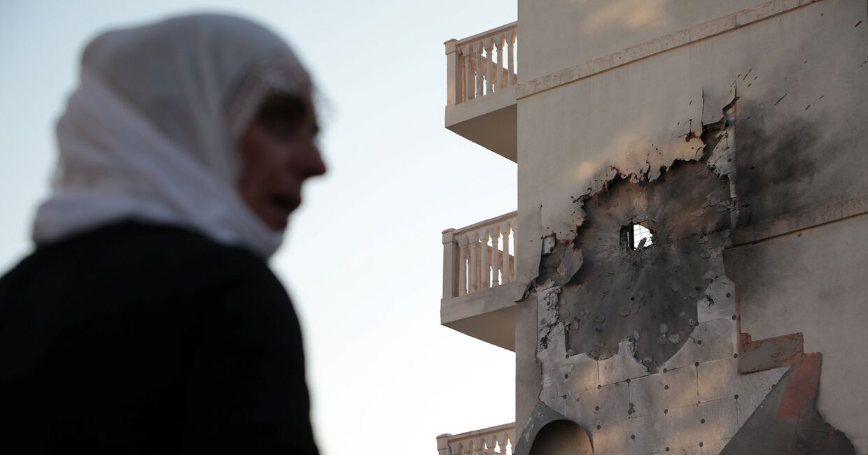Женщина у дома, который был поврежден ракетой, выпущенной с территории Сирии в Нусайбине