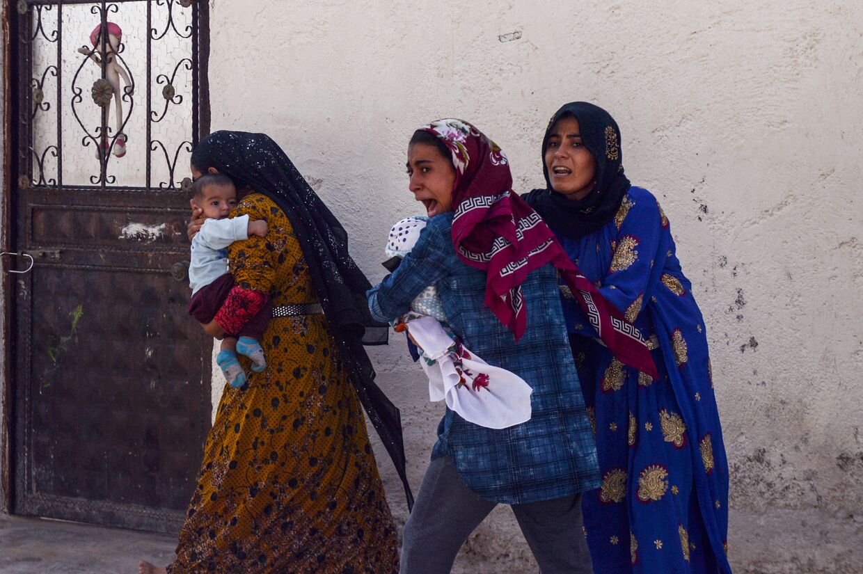 Женщины покидают свои дома в городе Акчакале во время обстрела города