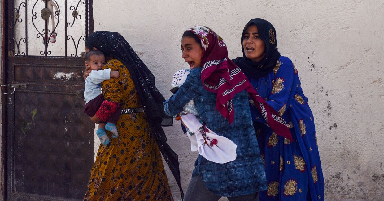 Женщины покидают свои дома в турецком городе Акчакале во время обстрела города