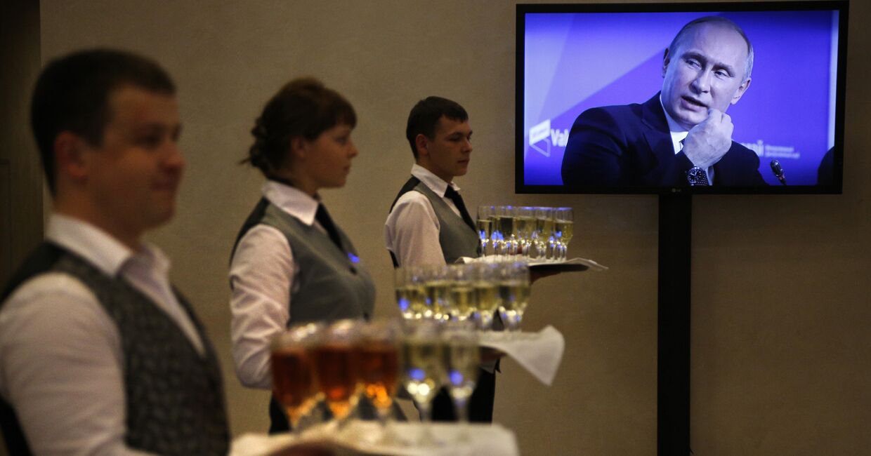 Официанты с шампанским у телевизора с трансляцией выступления Владимира Путина
