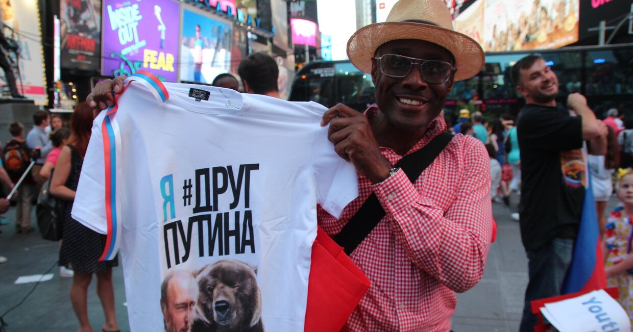 Мужчина на улице в Нью-Йорке демонстрирует футболку с изображением российского президента