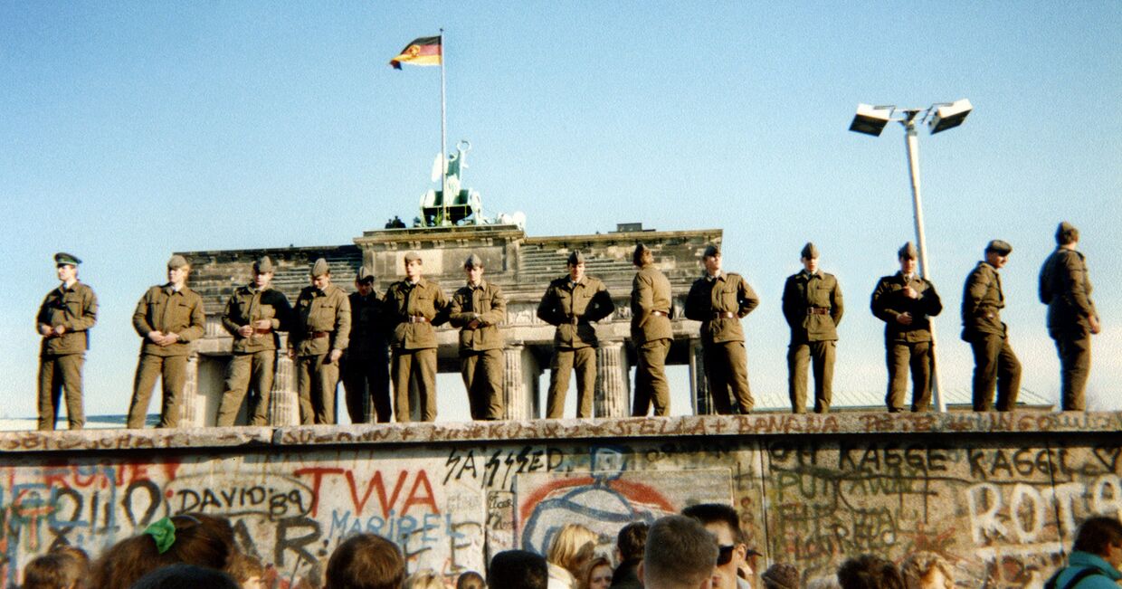 Восточногерманские пограничники стоят на участке Берлинской стены у Бранденбургских ворот
